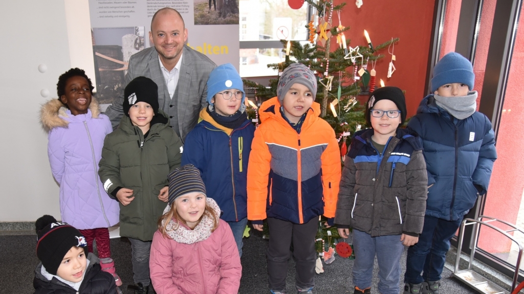 Gemeinsam erfolgreich: Kinder der Albert-Schweitzer-Kita haben den Tannenbaum an der Rathauseingangstür geschmückt, mit Unterstützung von Bürgermeister Pascal Seidel.