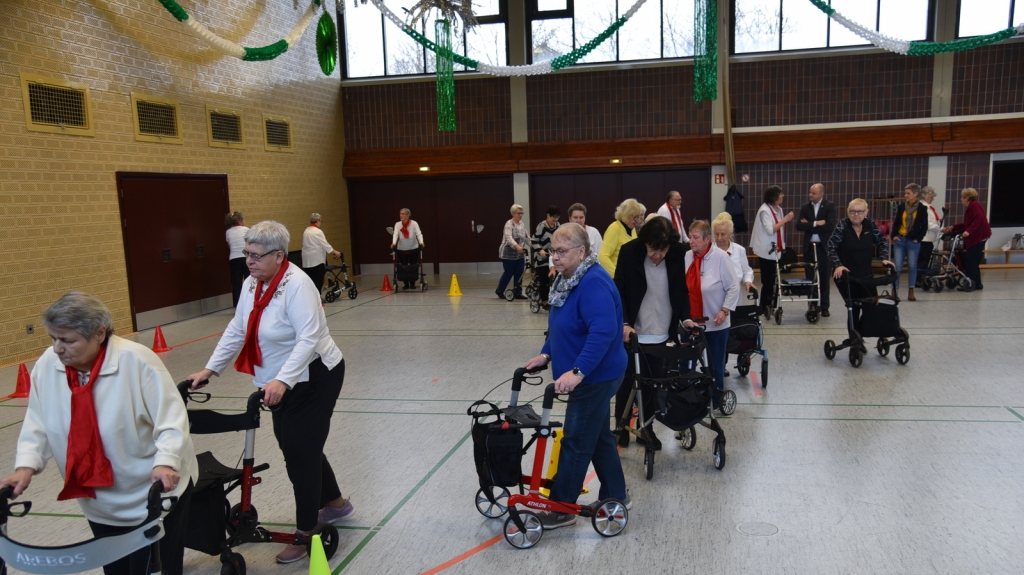 Alle Seniorinnen und Senioren üben den Parcourslauf mit dem Rollator.