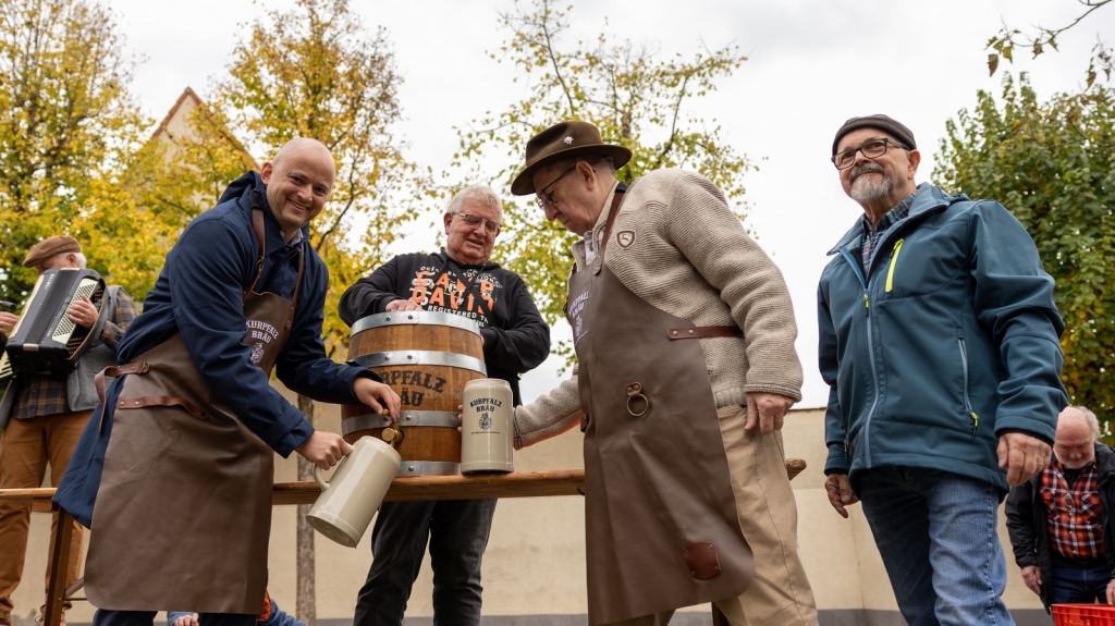 Zum Kerweauftakt wurde das Fassbier angestochen. Bürgermeister Pascal Seidel zapft das erste Bier, daneben Vertreter des Heimat-und Kulturkreises.