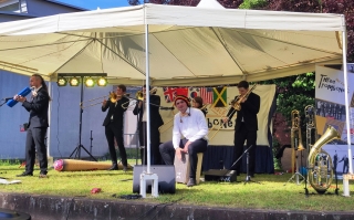 Die Musiker von Three and a half Trombones mit ihren Instrumenten im Gemeindepark.