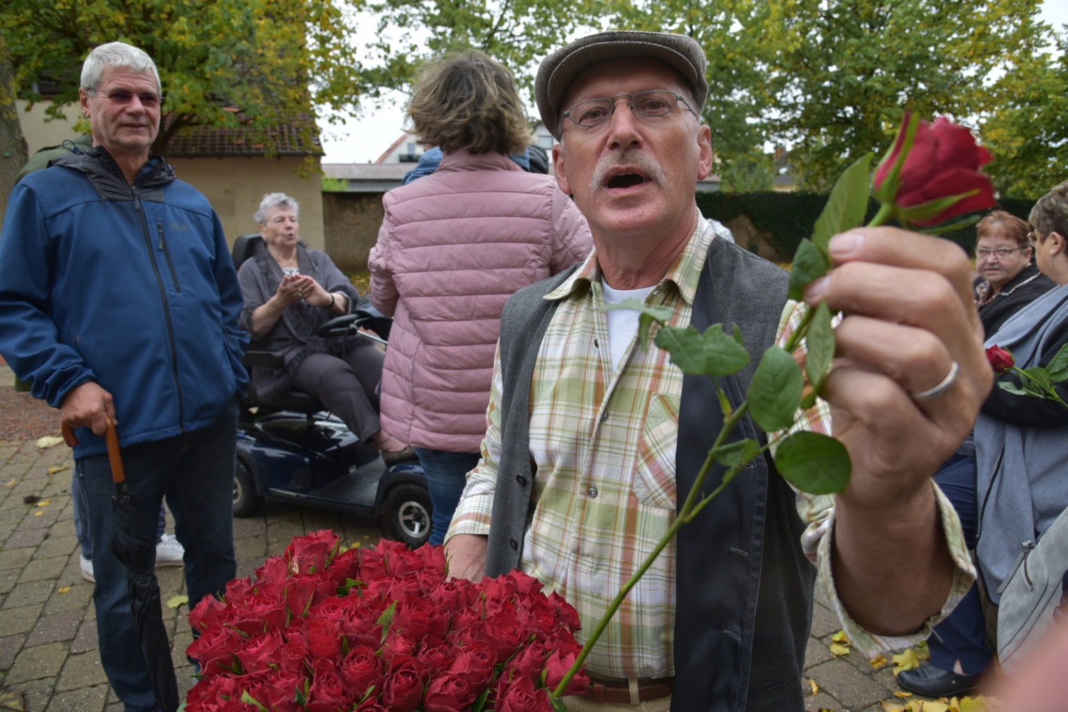 Kerweborschd Manfred Müller verteilt rote Rosen.