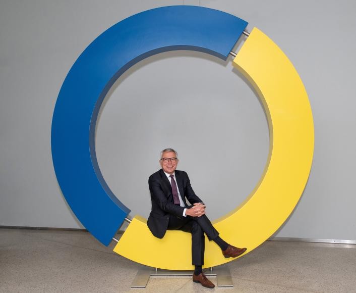 Landrat Stefan Dallinger sitzend auf dem Kreislogo des Rhein-Neckar-Kreises Landrat Stefan Dallinger sitzend auf dem Kreislogo des Rhein-Neckar-Kreises
